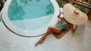 Mini piscine ronde avec femme allongée à côté avec un grand chapeau