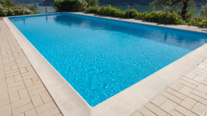 Grande piscine creusée bleu avec vue sur un lac et la montagne